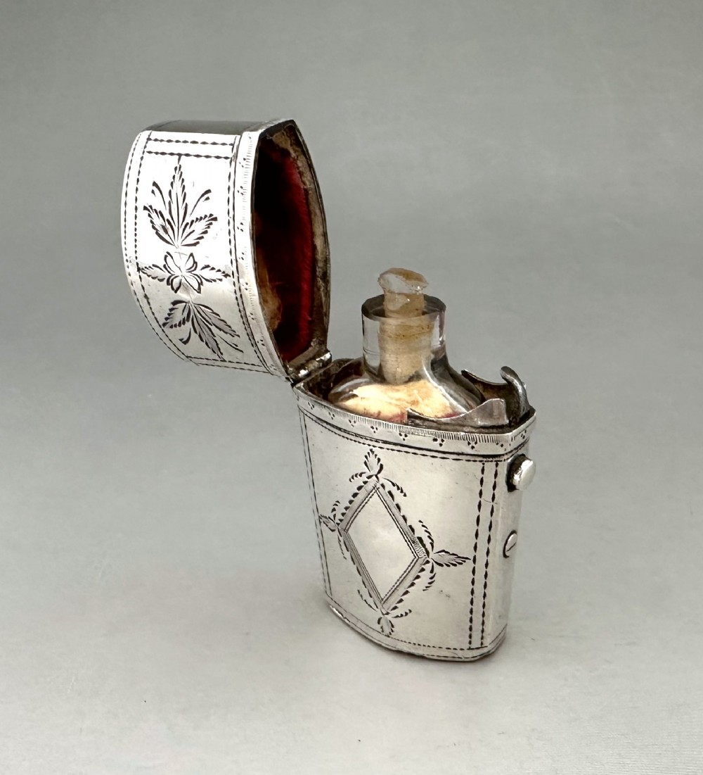 An antique Georgian sterling silver scent bottle case decorated with hand-engraved leaf and diamond motifs. View V