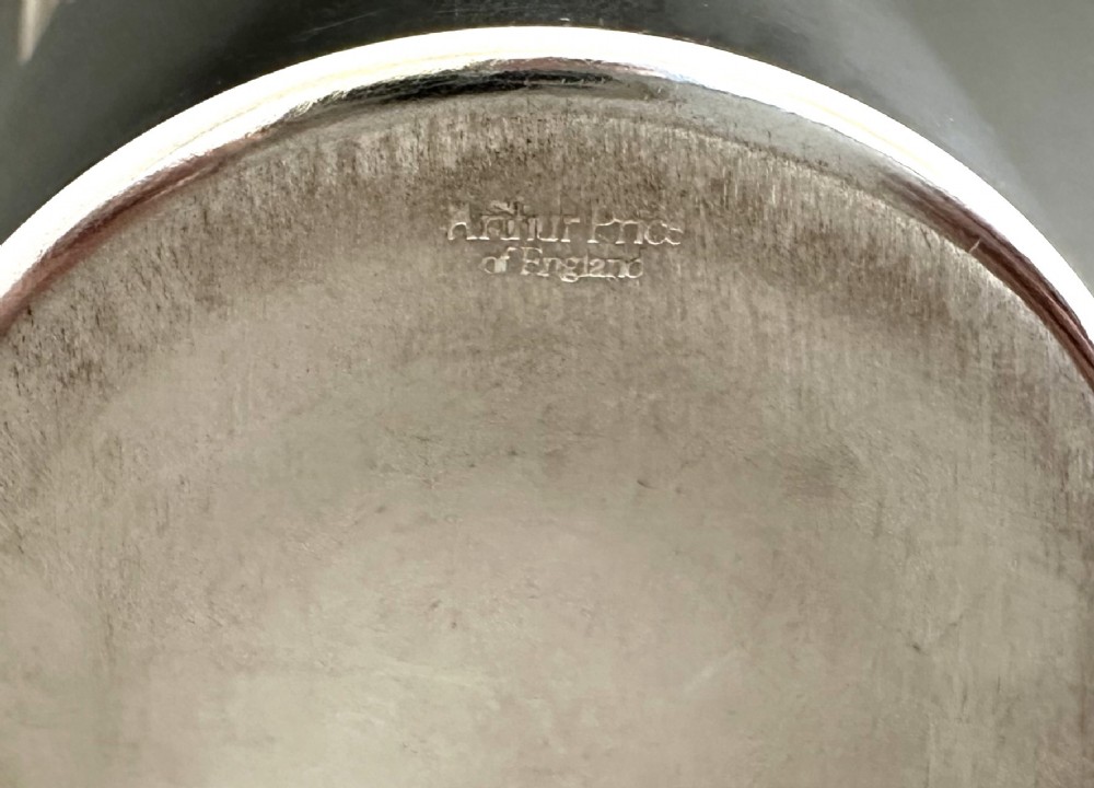 A polished silver-plated three-piece Art Deco cocktail shaker featuring a tapered cylindrical body with incised lines and a stepped cap. View VI