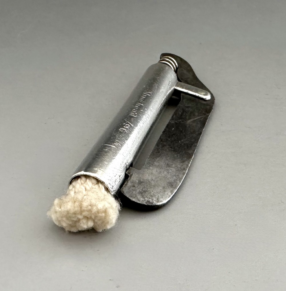 An antique Victorian silver tinder tube with engraved maker details, a steel striker plate, and a protruding cotton wick. View IV
