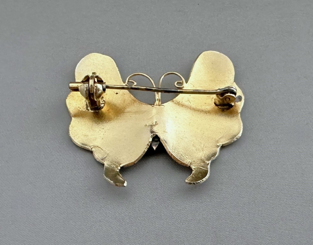 An antique butterfly brooch constructed from silver gilt and detailed with green, white, and burgundy enamel on the wings. View III