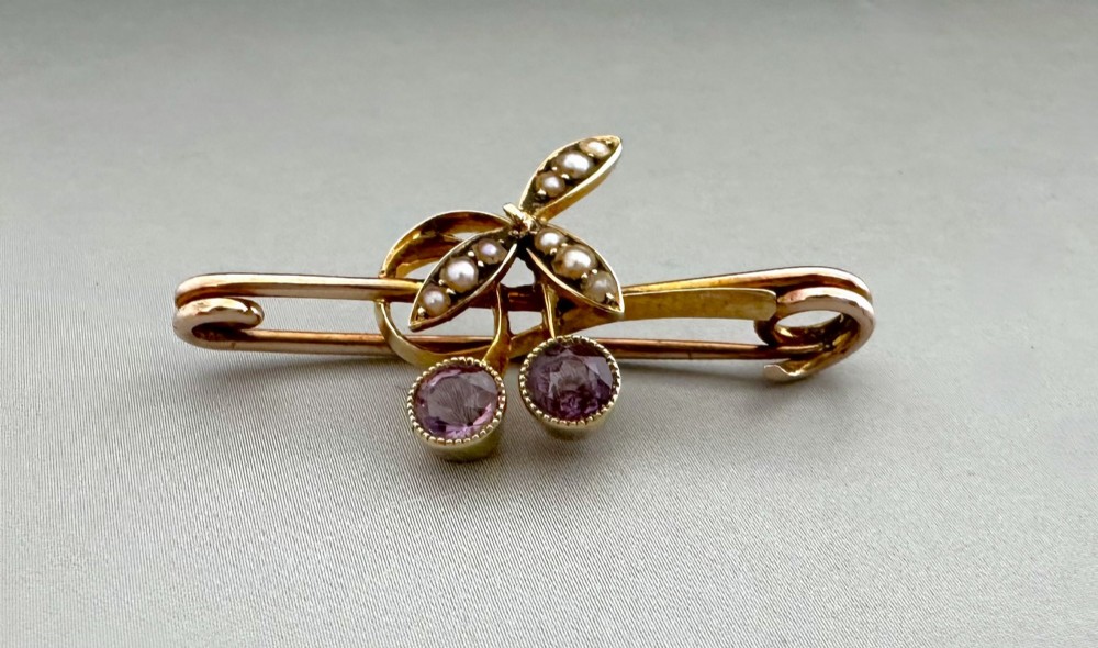 Victorian 9ct gold bar brooch featuring a central cherry motif with seed pearl leaves and two faceted pink gemstones. View II