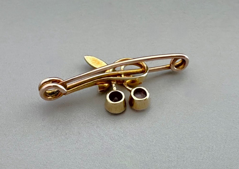 Victorian 9ct gold bar brooch featuring a central cherry motif with seed pearl leaves and two faceted pink gemstones. View IV