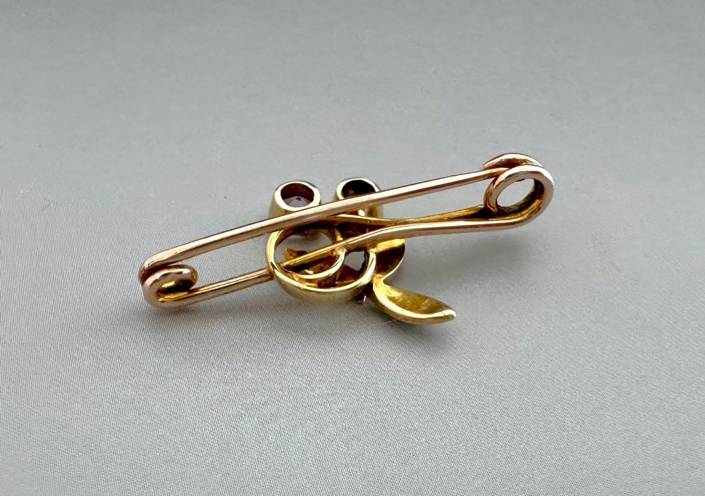 Victorian 9ct gold bar brooch featuring a central cherry motif with seed pearl leaves and two faceted pink gemstones. View V