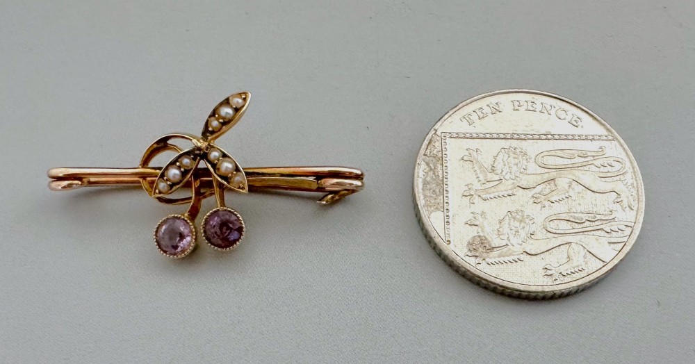 Victorian 9ct gold bar brooch featuring a central cherry motif with seed pearl leaves and two faceted pink gemstones. View VII