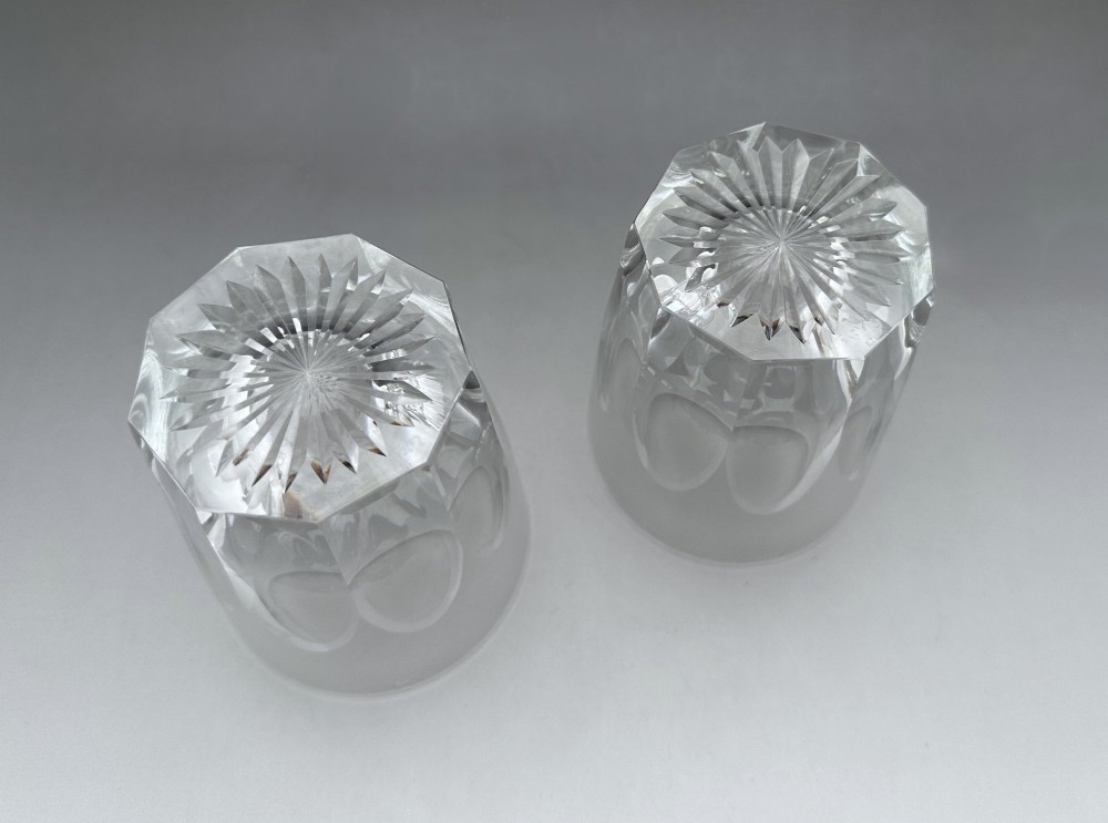A pair of clear cut glass whisky tumblers featuring arched facet cuts and starburst bases. View IV