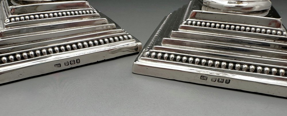 A pair of Victorian silver candlesticks featuring fluted Corinthian columns with acanthus leaf capitals on stepped square bases with beaded rims. View VIII