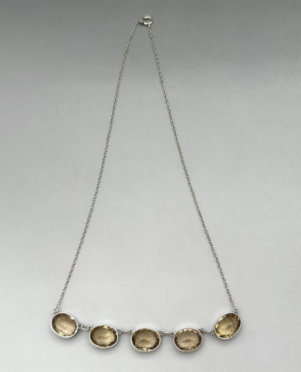 An early twentieth-century fine silver chain necklace set with five oval faceted citrine gemstones in bezel mountings. View II