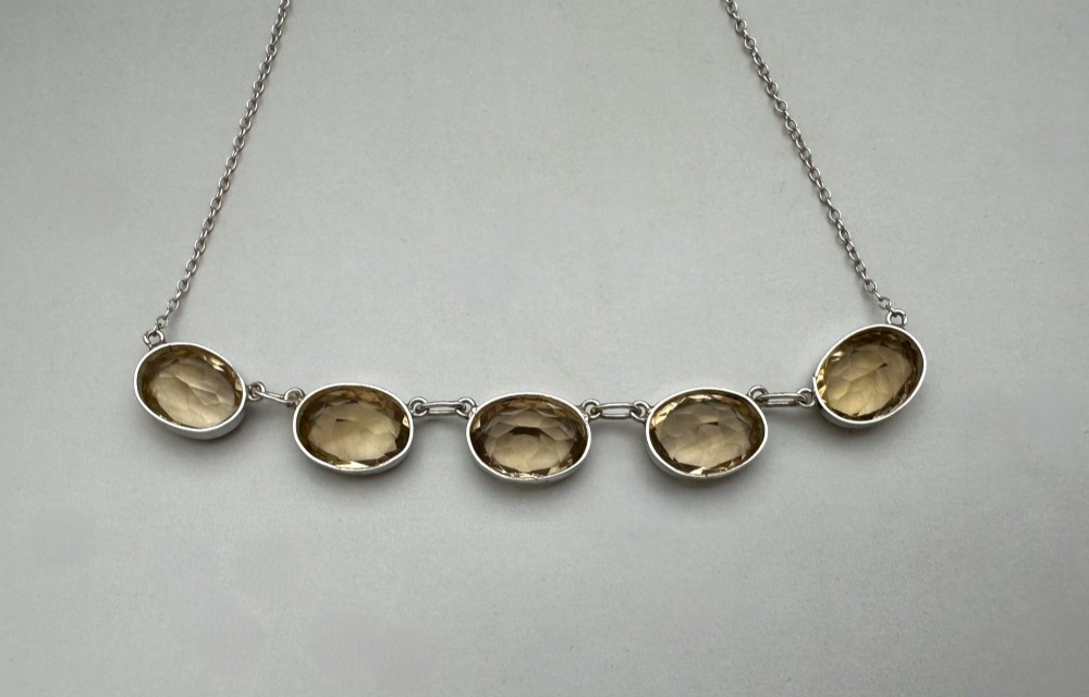 An early twentieth-century fine silver chain necklace set with five oval faceted citrine gemstones in bezel mountings. View III
