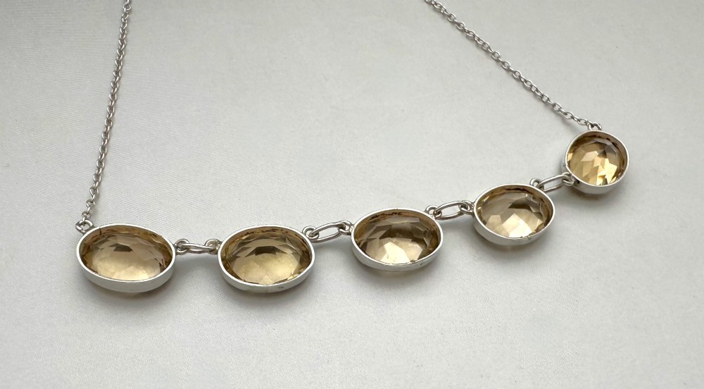 An early twentieth-century fine silver chain necklace set with five oval faceted citrine gemstones in bezel mountings. View IV
