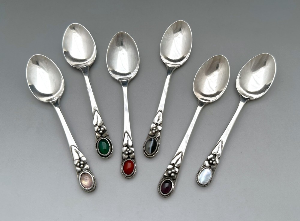 A boxed set of six Scottish sterling silver demi-tasse spoons set with varied semi-precious cabochon stones in a blue fitted case. View III
