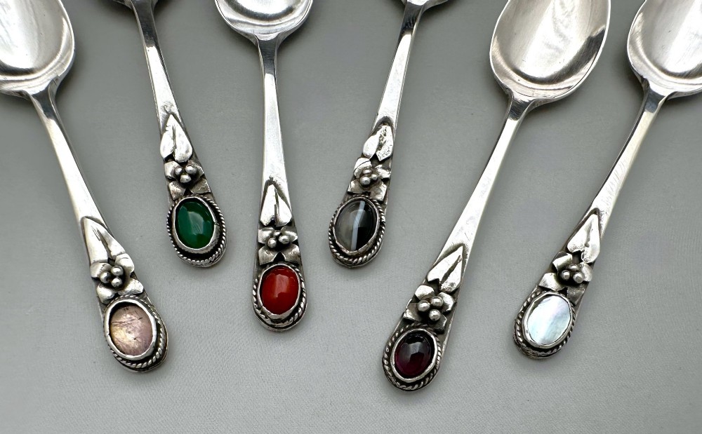 A boxed set of six Scottish sterling silver demi-tasse spoons set with varied semi-precious cabochon stones in a blue fitted case. View IV