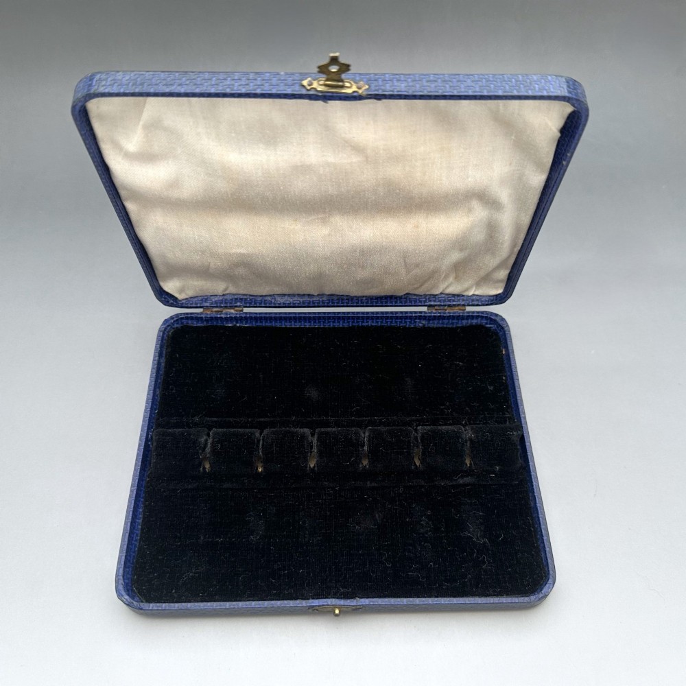 A boxed set of six Scottish sterling silver demi-tasse spoons set with varied semi-precious cabochon stones in a blue fitted case. View X