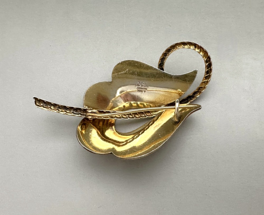 A leaf-shaped Norwegian silver gilt brooch featuring layered yellow guilloche enamel and twisted silver accents. View IV