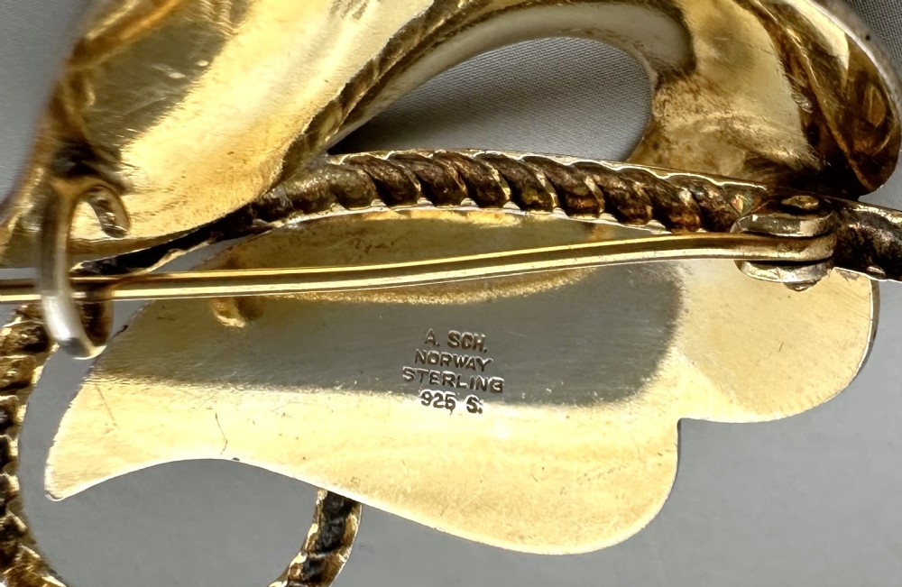 A leaf-shaped Norwegian silver gilt brooch featuring layered yellow guilloche enamel and twisted silver accents. View VI