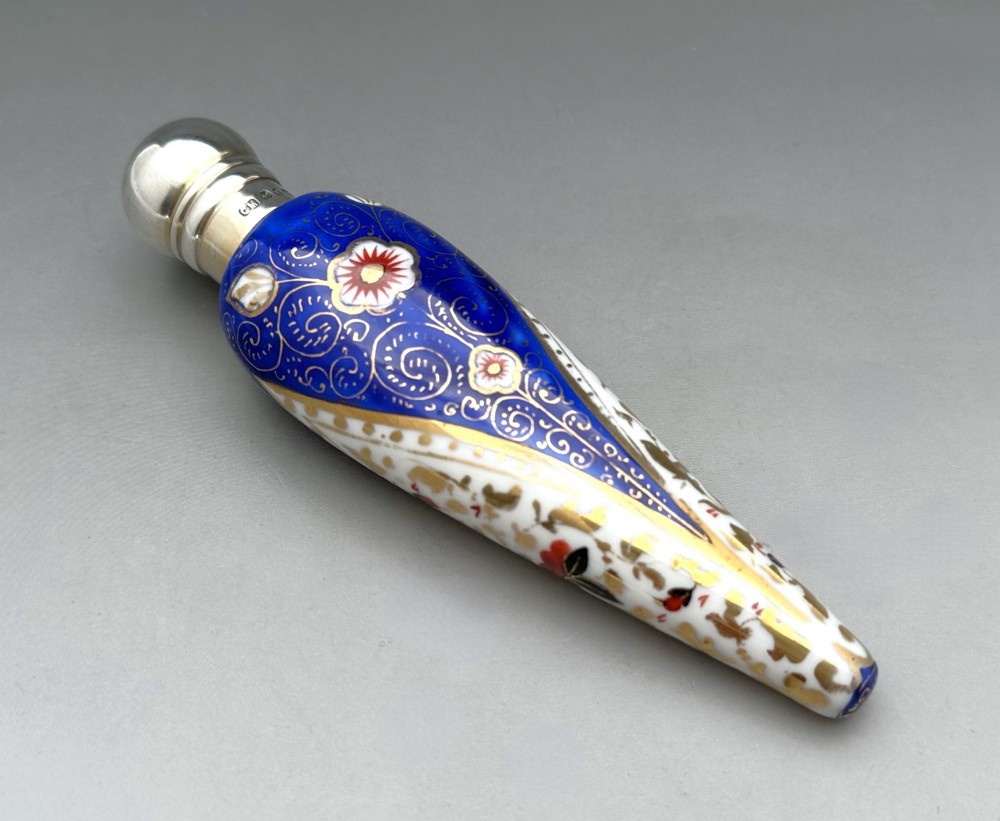 A Victorian teardrop-shaped porcelain scent bottle decorated with blue, red, and gold Imari motifs, featuring a silver spherical cap. View II