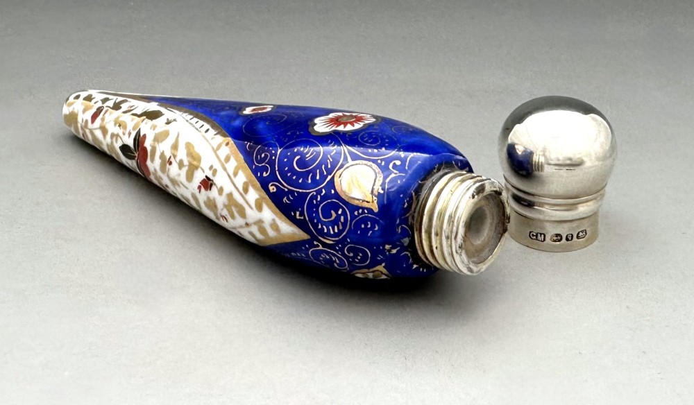 A Victorian teardrop-shaped porcelain scent bottle decorated with blue, red, and gold Imari motifs, featuring a silver spherical cap. View V