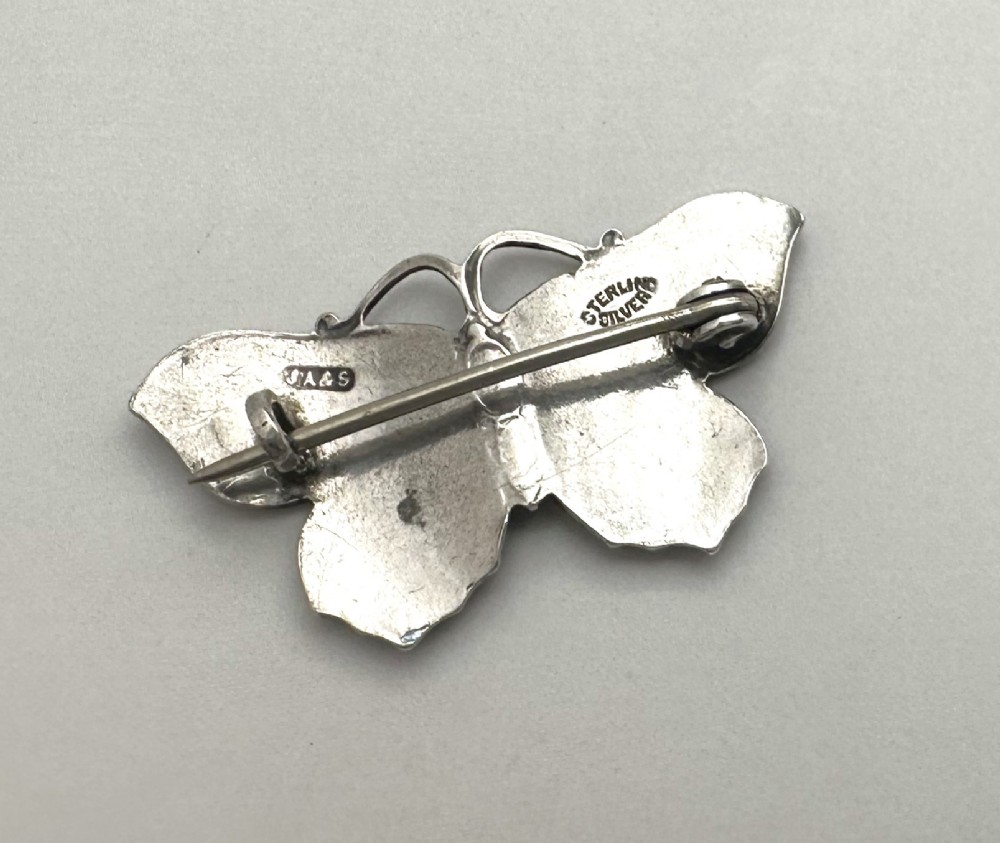 An Edwardian silver butterfly brooch featuring purple textured guilloche enamel wings and a green enamelled body. View III
