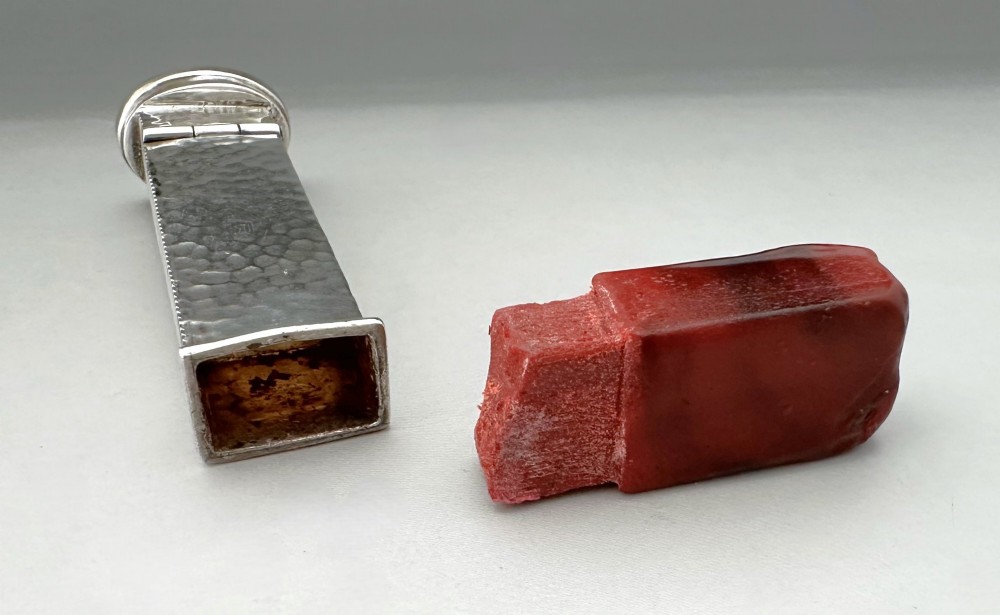 An Edwardian sterling silver vesta case with a hand-hammered finish and ribbed sides, fitted with a stick of red sealing wax. View VI