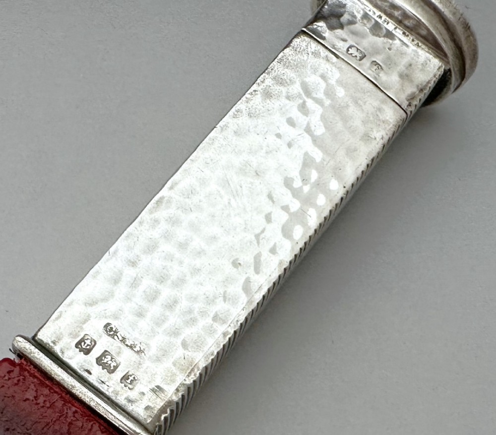 An Edwardian sterling silver vesta case with a hand-hammered finish and ribbed sides, fitted with a stick of red sealing wax. View VII