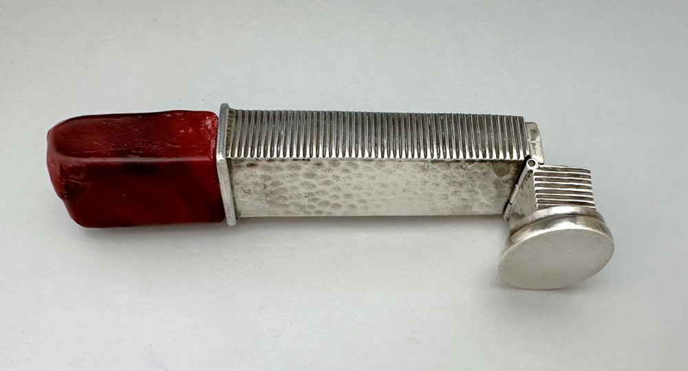 An Edwardian sterling silver vesta case with a hand-hammered finish and ribbed sides, fitted with a stick of red sealing wax. View VIII