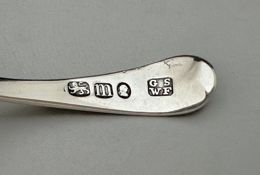 An 18th-century sterling silver caddy spoon featuring a fluted shell-shaped bowl and an intricately engraved handle. View VI