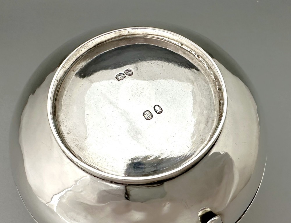 A George IV sterling silver cream jug with a polished surface, horizontal reeded decoration on the waist, a wide pour spout, and a curved high-loop handle. View IX