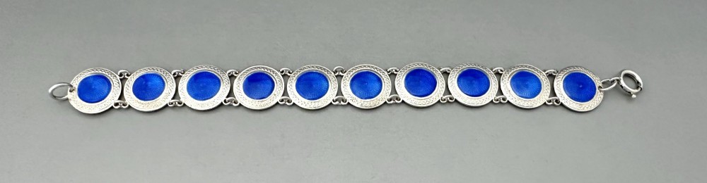 An Art Deco silver link bracelet featuring circular panels filled with cobalt blue guilloche enamel. View II