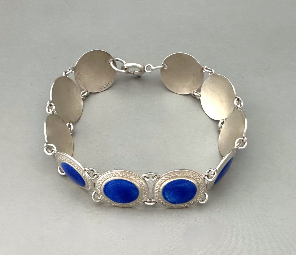 An Art Deco silver link bracelet featuring circular panels filled with cobalt blue guilloche enamel. View III