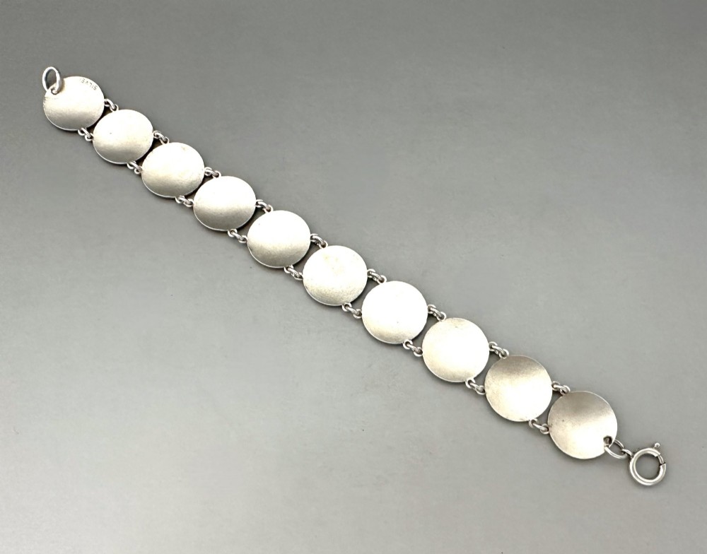 An Art Deco silver link bracelet featuring circular panels filled with cobalt blue guilloche enamel. View IV
