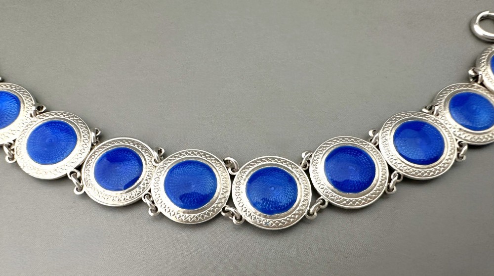 An Art Deco silver link bracelet featuring circular panels filled with cobalt blue guilloche enamel. View V
