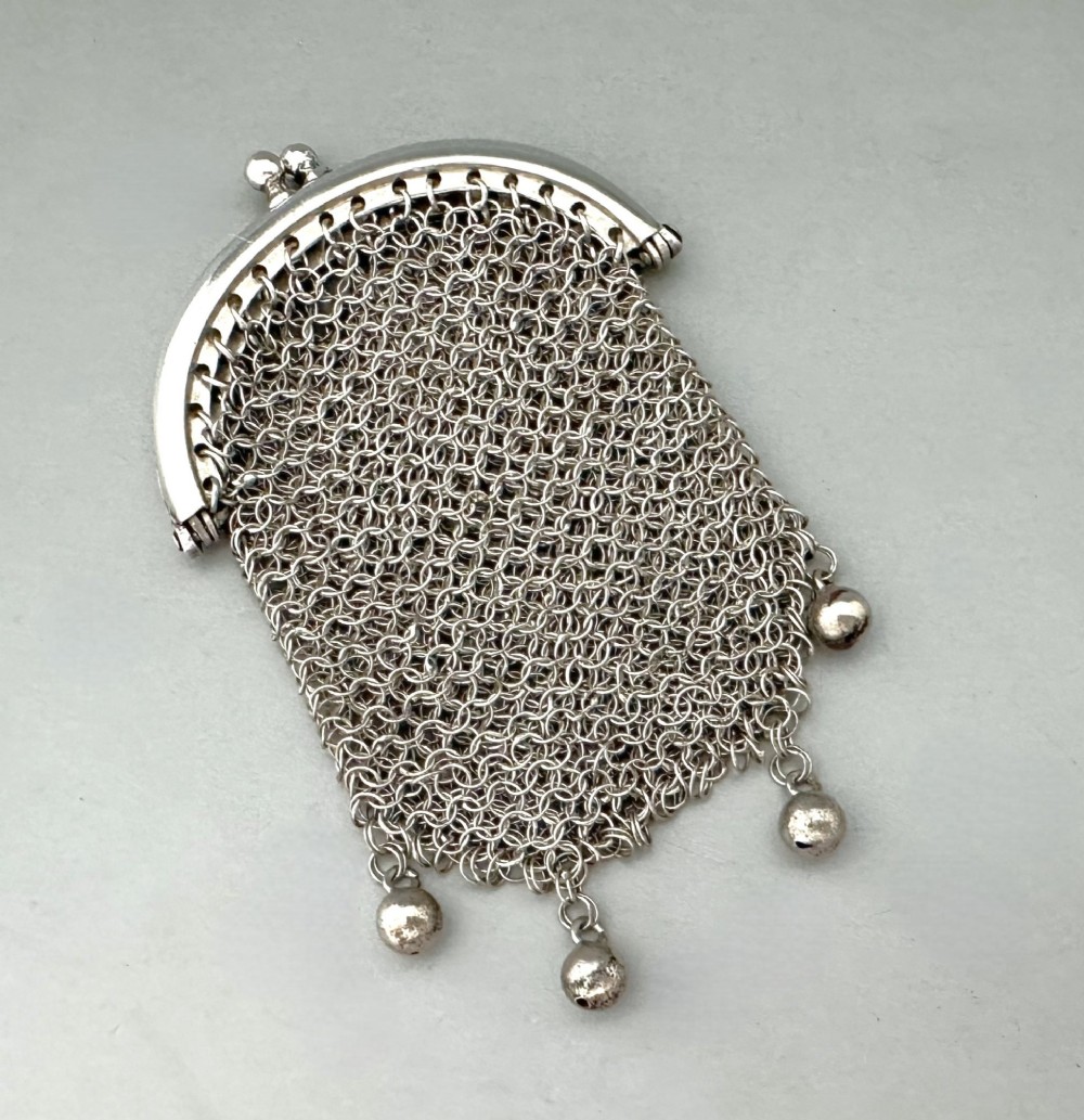 A petite French silver chainmail purse featuring a curved kiss-clasp frame and small silver spherical drops attached along the bottom seam. View II