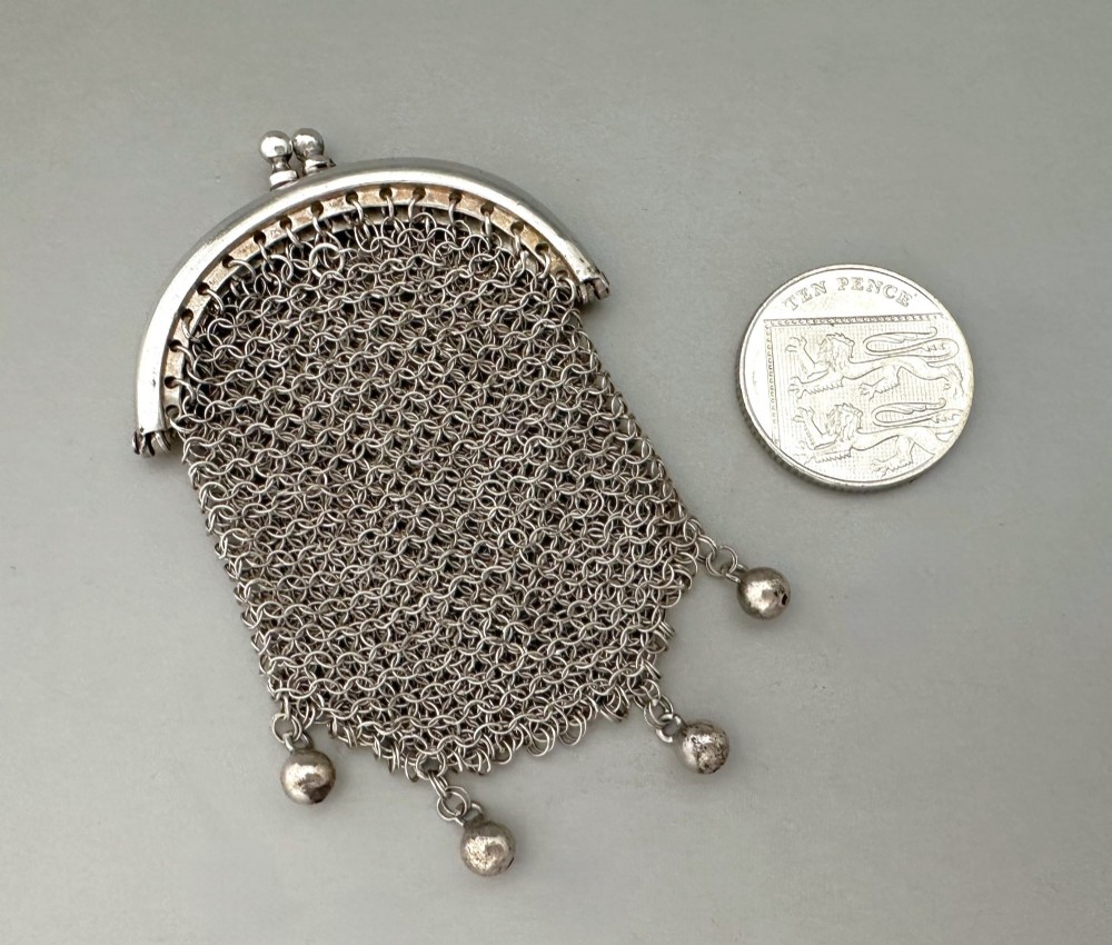 A petite French silver chainmail purse featuring a curved kiss-clasp frame and small silver spherical drops attached along the bottom seam. View VI