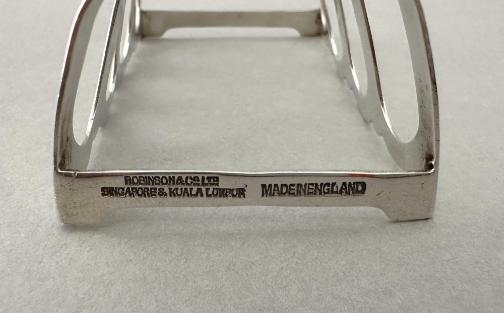A hallmarked silver four-slice toast rack featuring shaped Gothic arch dividers and a central pierced top handle. View VI