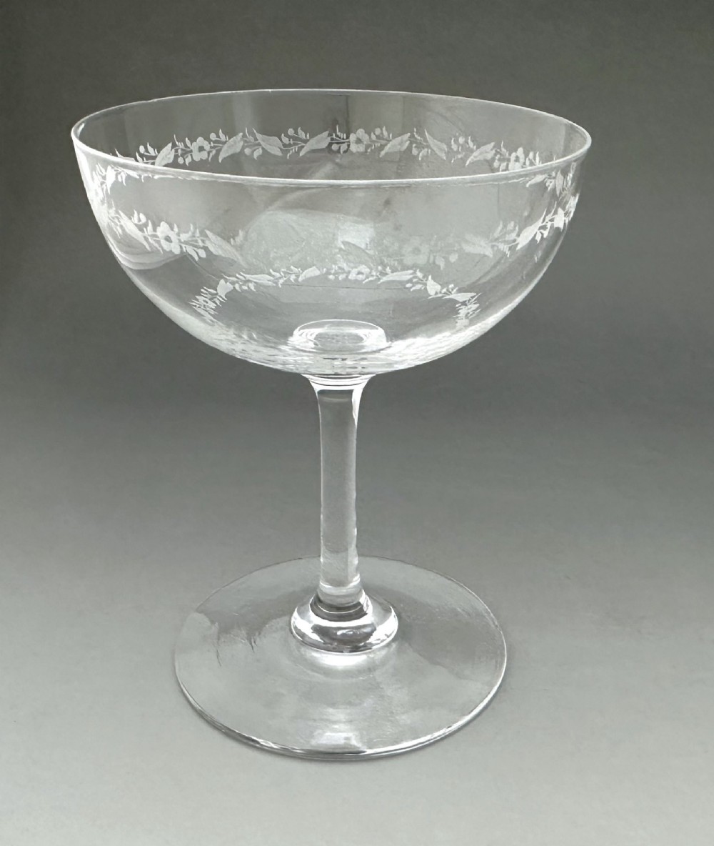 A harlequin set of six antique clear glass champagne coupes featuring various hand-etched geometric and floral patterns. View IV