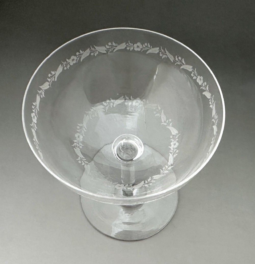A harlequin set of six antique clear glass champagne coupes featuring various hand-etched geometric and floral patterns. View V