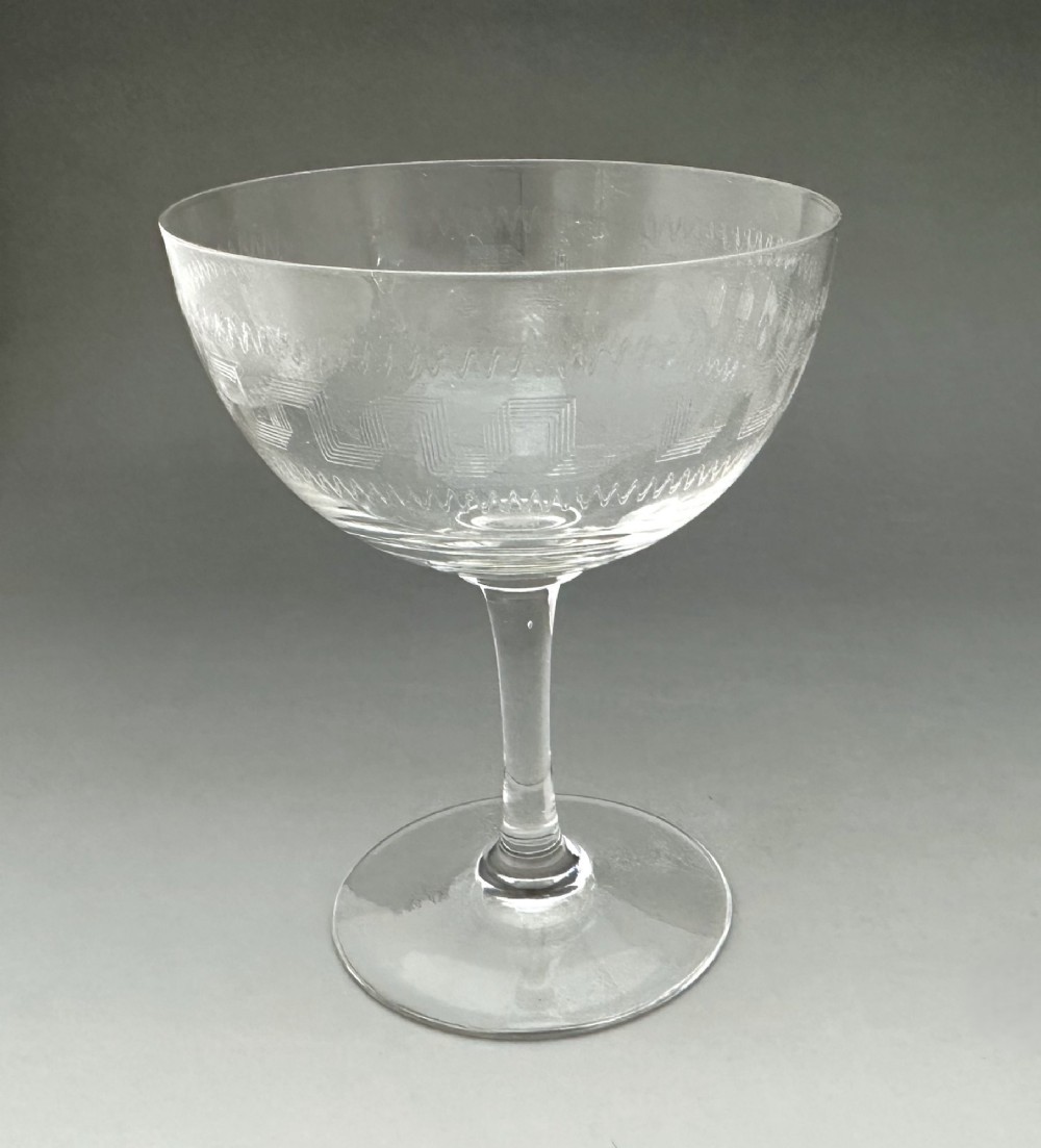 A harlequin set of six antique clear glass champagne coupes featuring various hand-etched geometric and floral patterns. View XII