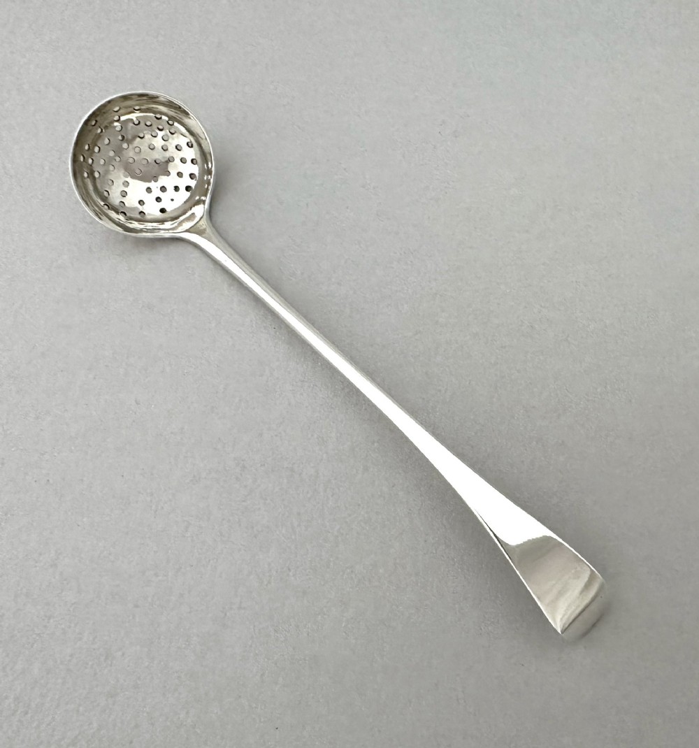 A Georgian sterling silver sifting ladle featuring a pierced round bowl and a smooth tapered handle. View II