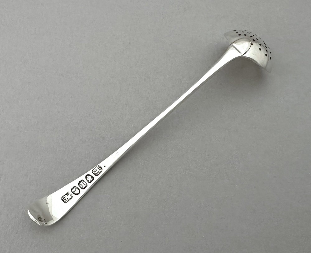 A Georgian sterling silver sifting ladle featuring a pierced round bowl and a smooth tapered handle. View IV