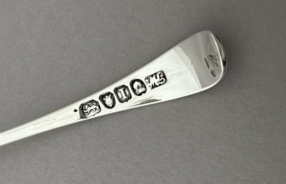 A Georgian sterling silver sifting ladle featuring a pierced round bowl and a smooth tapered handle. View VI