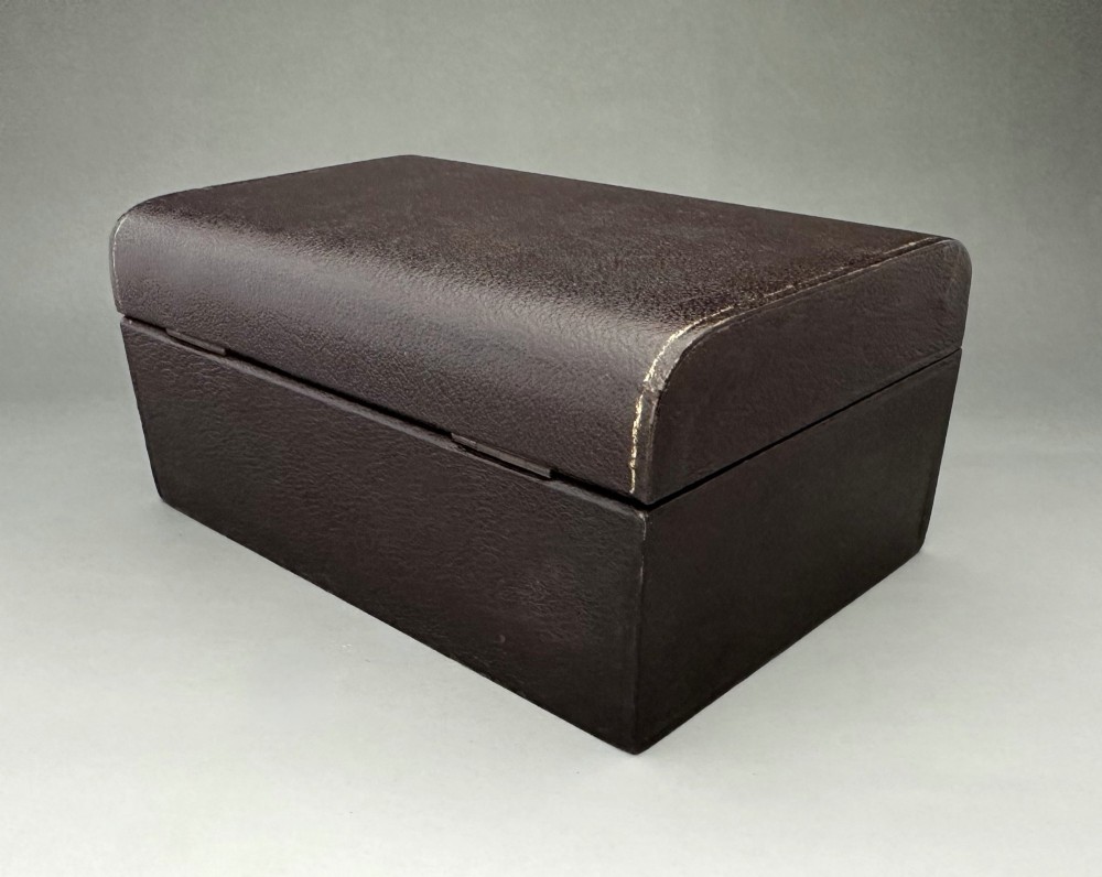 A dark brown leather Victorian jewellery box with a domed lid, subtle gilt edge tooling, and a metal keyhole escutcheon. View III