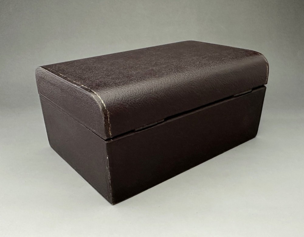 A dark brown leather Victorian jewellery box with a domed lid, subtle gilt edge tooling, and a metal keyhole escutcheon. View IV