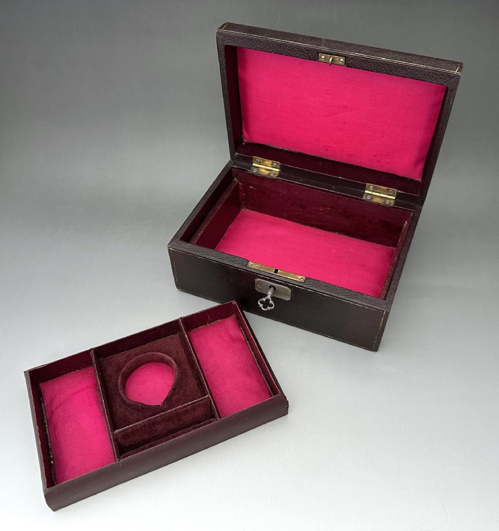 A dark brown leather Victorian jewellery box with a domed lid, subtle gilt edge tooling, and a metal keyhole escutcheon. View VII