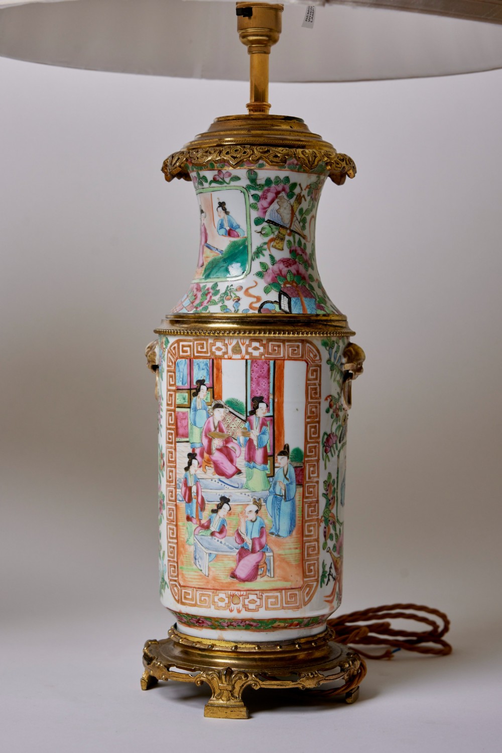 A pair of Chinese porcelain vase table lamps with hand-painted figures, gilt metal mounts, and cream pleated fabric shades. View III