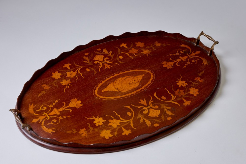 An oval mahogany serving tray featuring a scalloped rim, twin brass handles, floral marquetry, and a central inlaid shell motif. View III