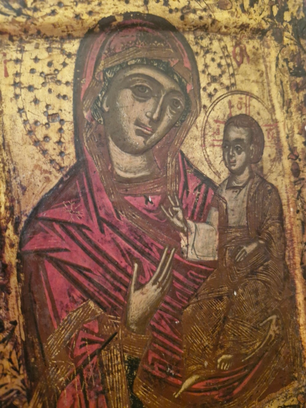 A rectangular wooden devotional icon panel featuring a gilded border and a painted depiction of the Virgin Mary holding the Christ Child. View II