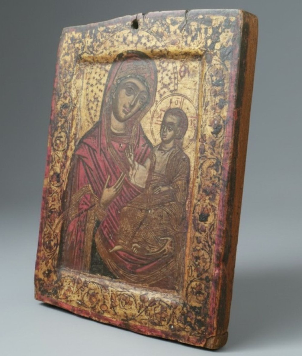 A rectangular wooden devotional icon panel featuring a gilded border and a painted depiction of the Virgin Mary holding the Christ Child. View III