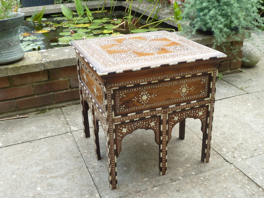 A square Anglo-Indian wooden side table with intricate bone inlay floral patterns and arched aprons.