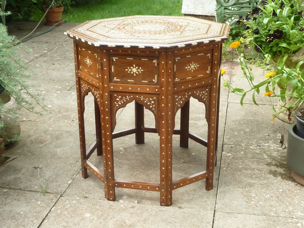 An Anglo-Indian octagonal wooden table featuring intricate bone inlay with geometric and floral motifs above Moorish arched lower aprons. View II