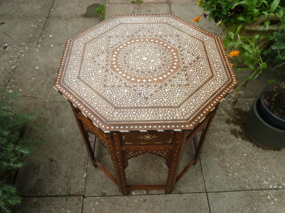 An Anglo-Indian octagonal wooden table featuring intricate bone inlay with geometric and floral motifs above Moorish arched lower aprons. View III