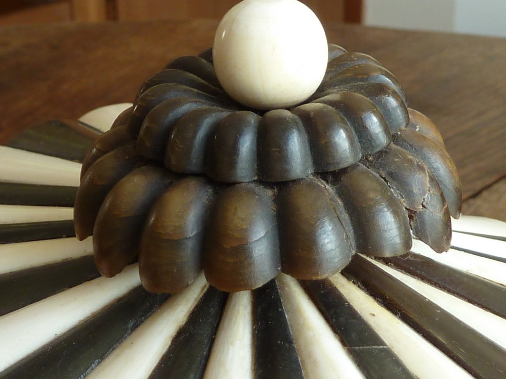An Anglo-Indian sarcophagus-form workbox featuring porcupine quill panels, engraved bone borders, and a sunburst horn and bone lid finial. View V